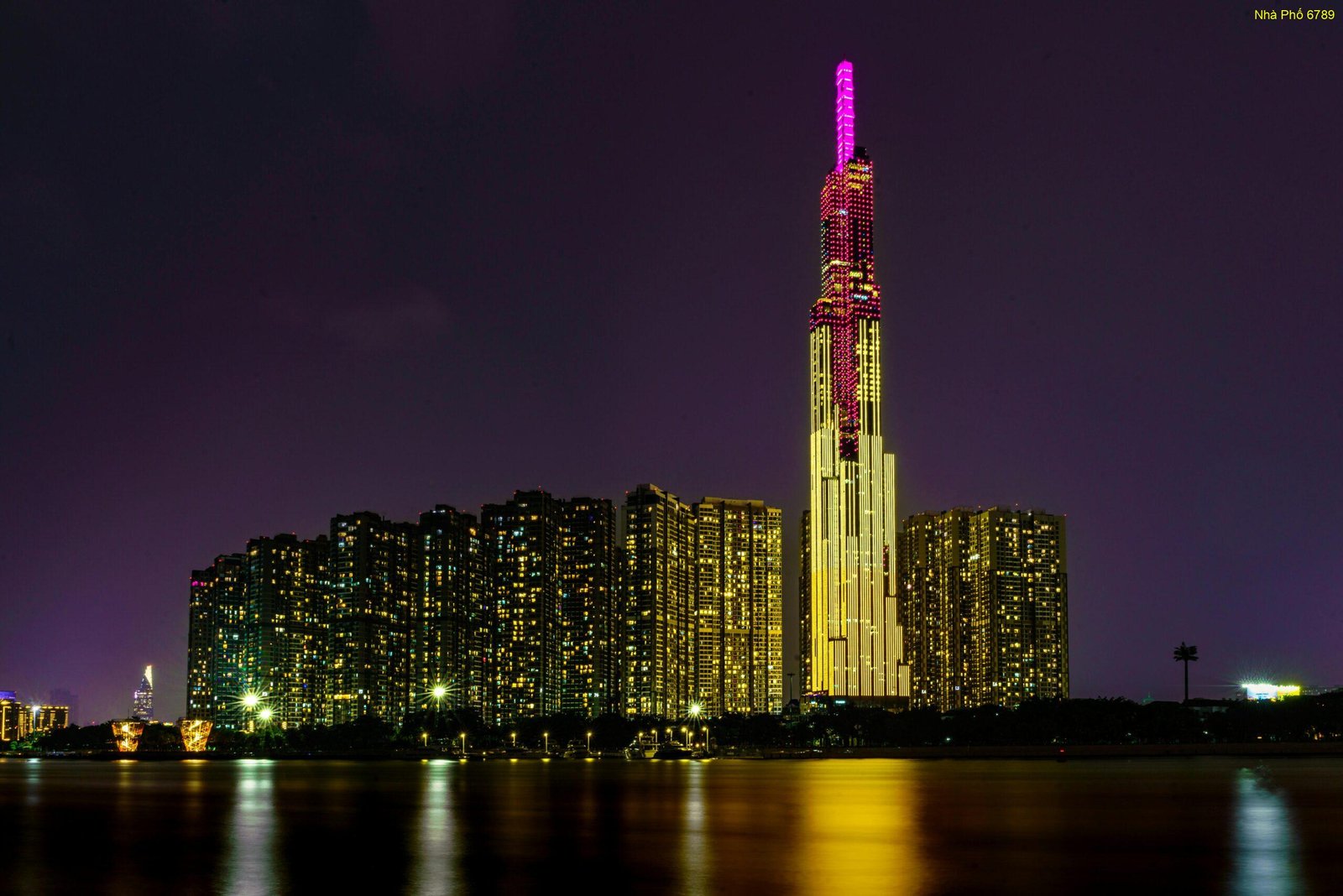 Vibrant night view of Ho Chi Minh City's Landmark 81 tower, lit up against the skyline.